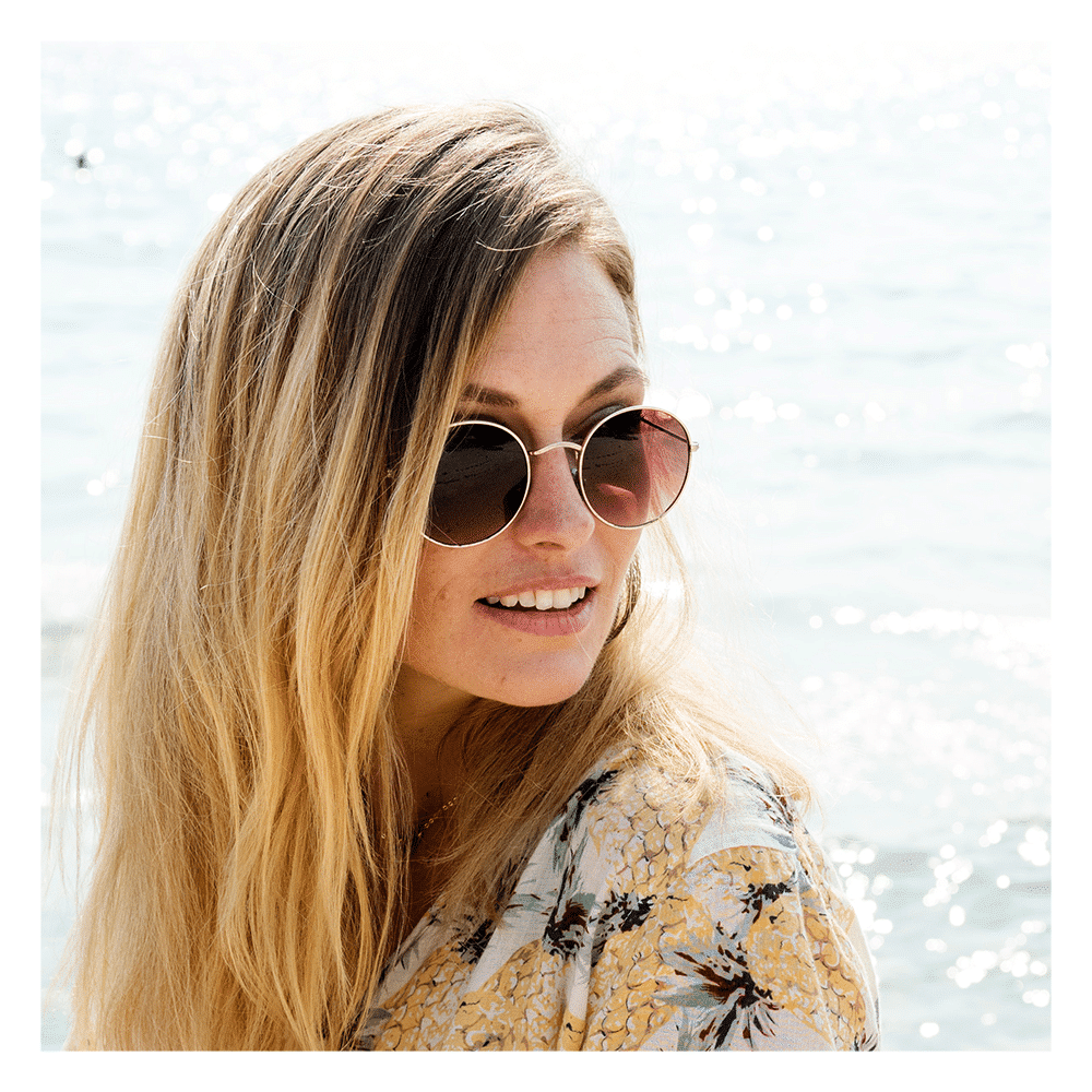 woman by the beach wearing sunglasses