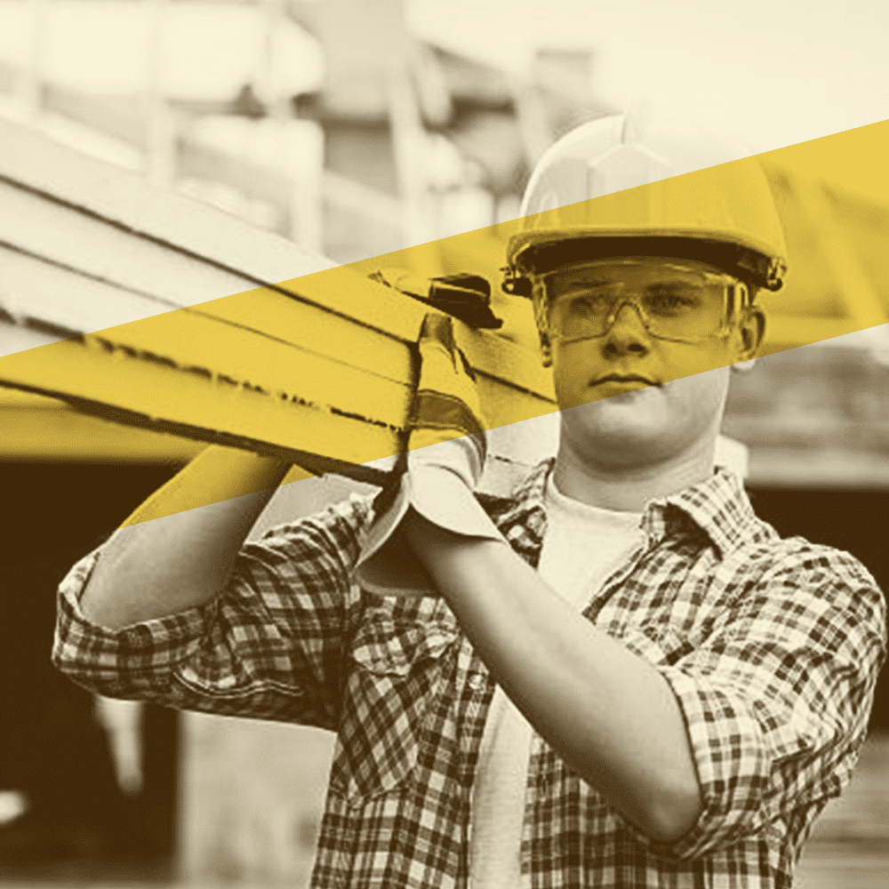 construction worker carrying steel while wearing hardhat