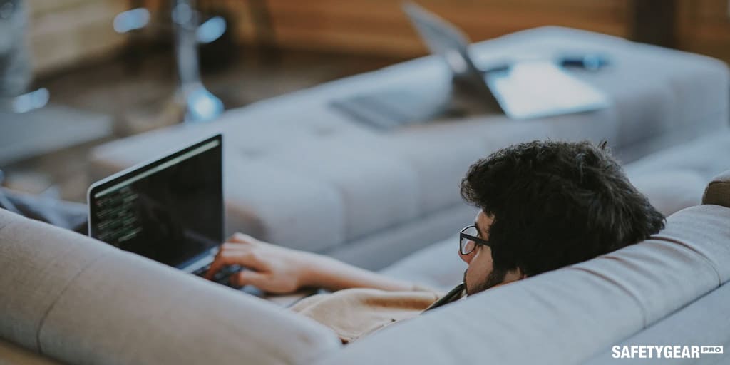 man on the couch working with his laptop