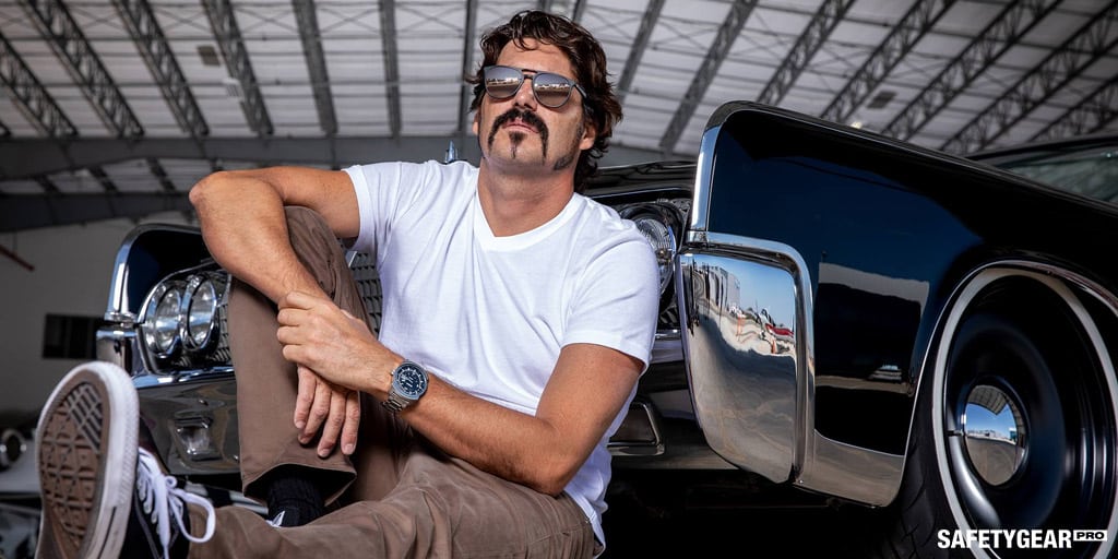 man wearing sunglasses sitting outside his car