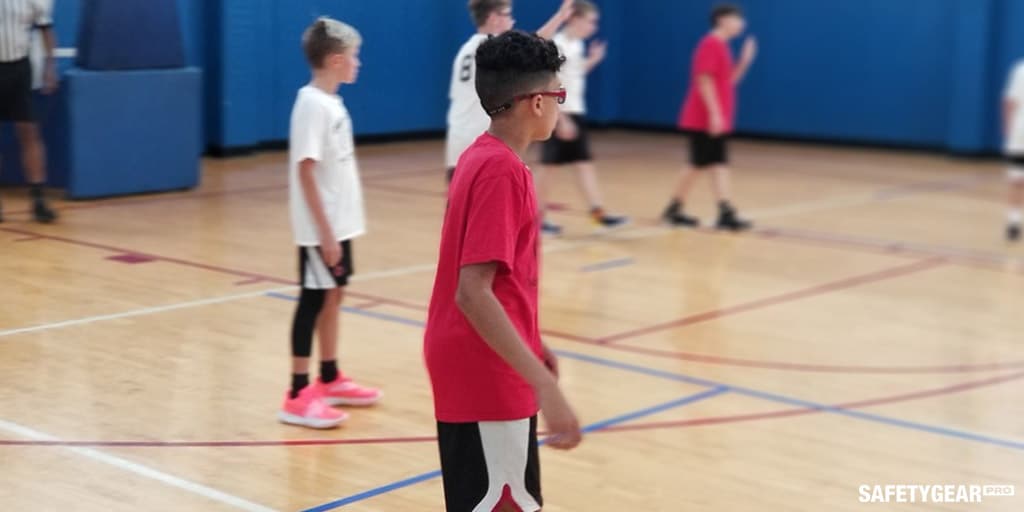 kid in red wearing glasses while playing basketball