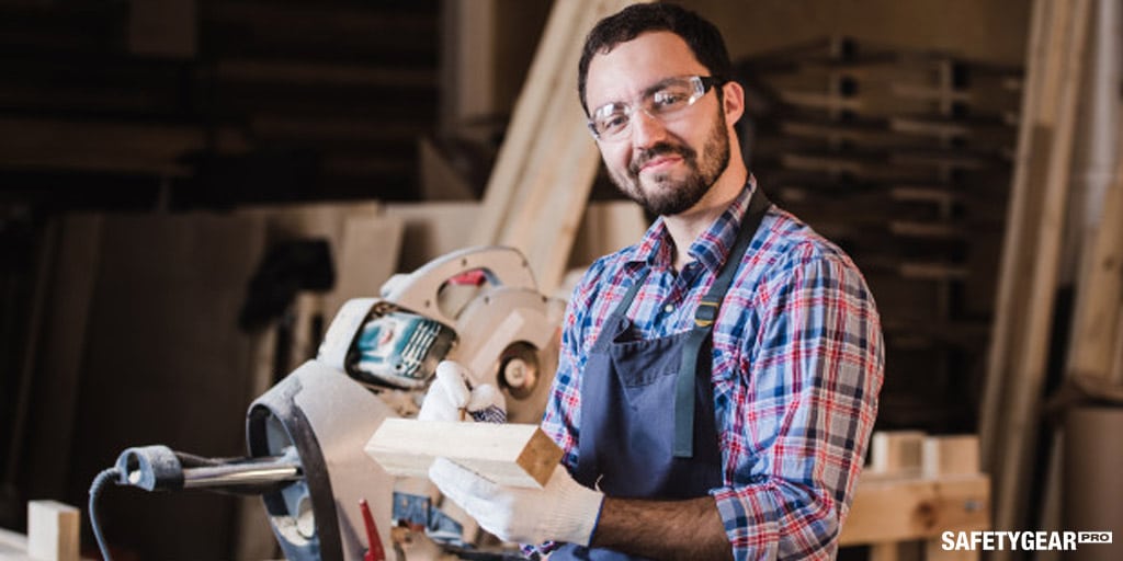 Man doing woodworks while wearing protecting glasses