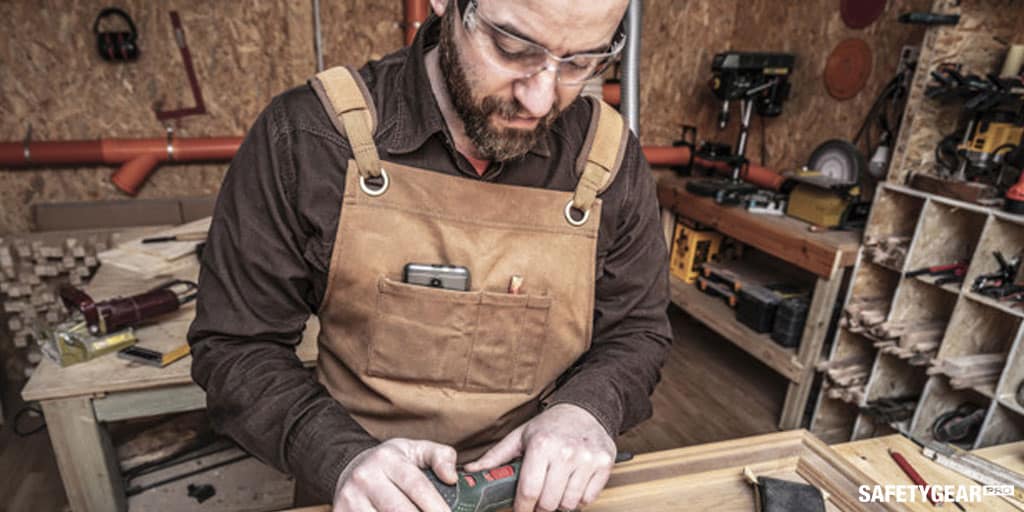 man wearing safety glasses while doing woodwork