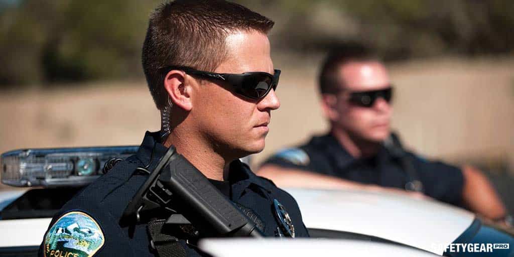 Police officers by the car wearing special sunglasses