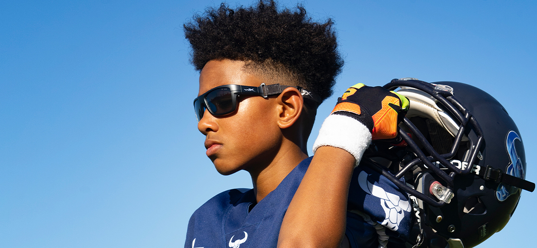Kid holding a helmet with sunglasses